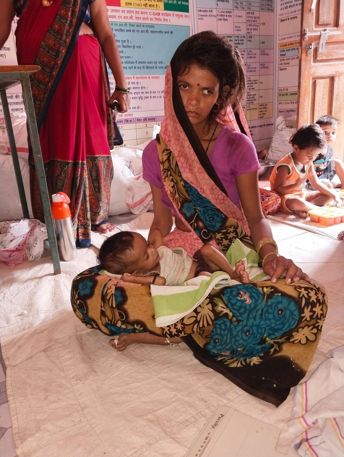 A mother holding her infant during a community outreach visit