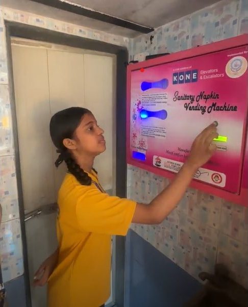 A student using a sanitary pad vending machine installed in her school